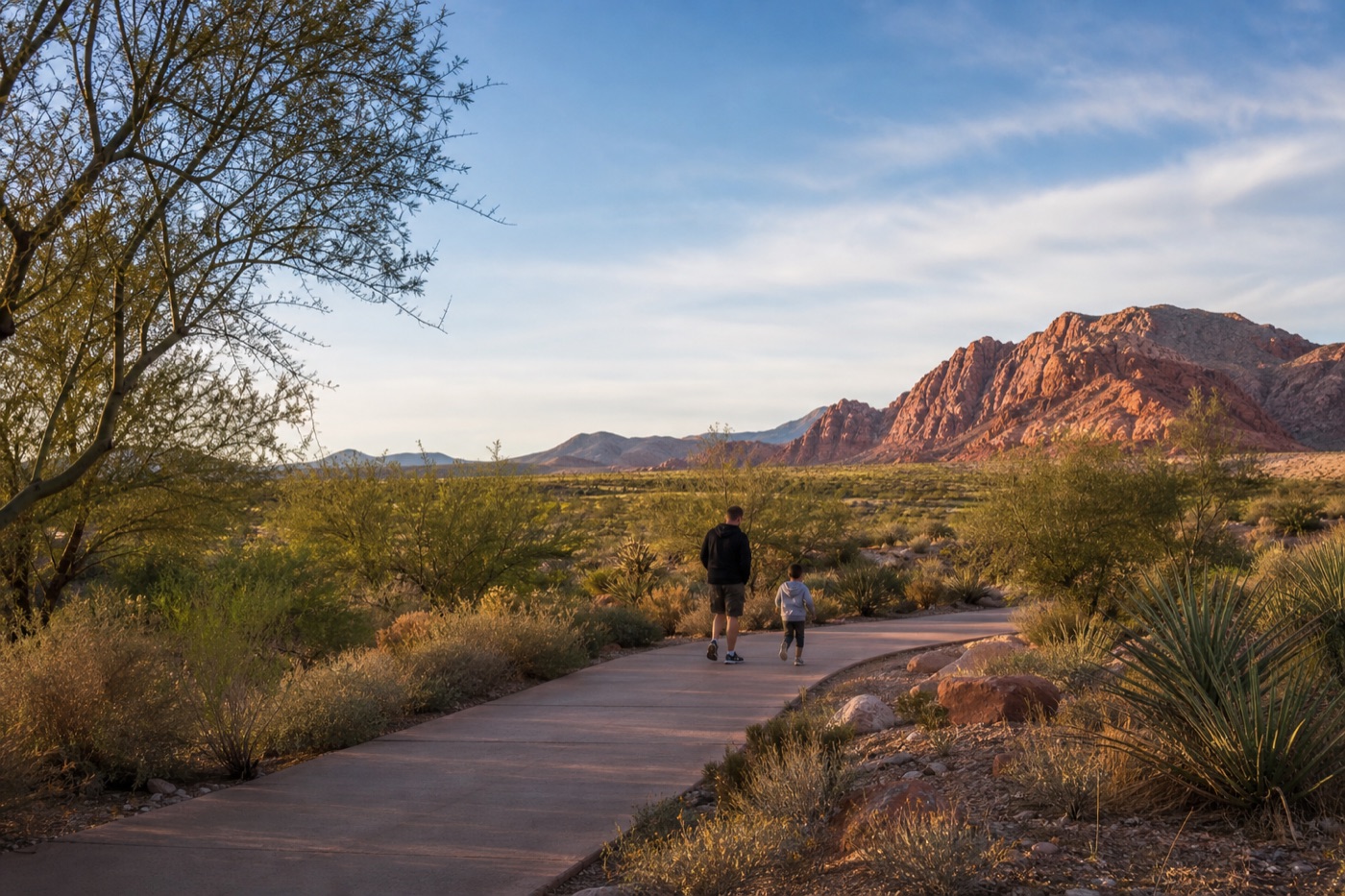 Parent and child on a quiet Las Vegas desert park path during an early family weekend outing