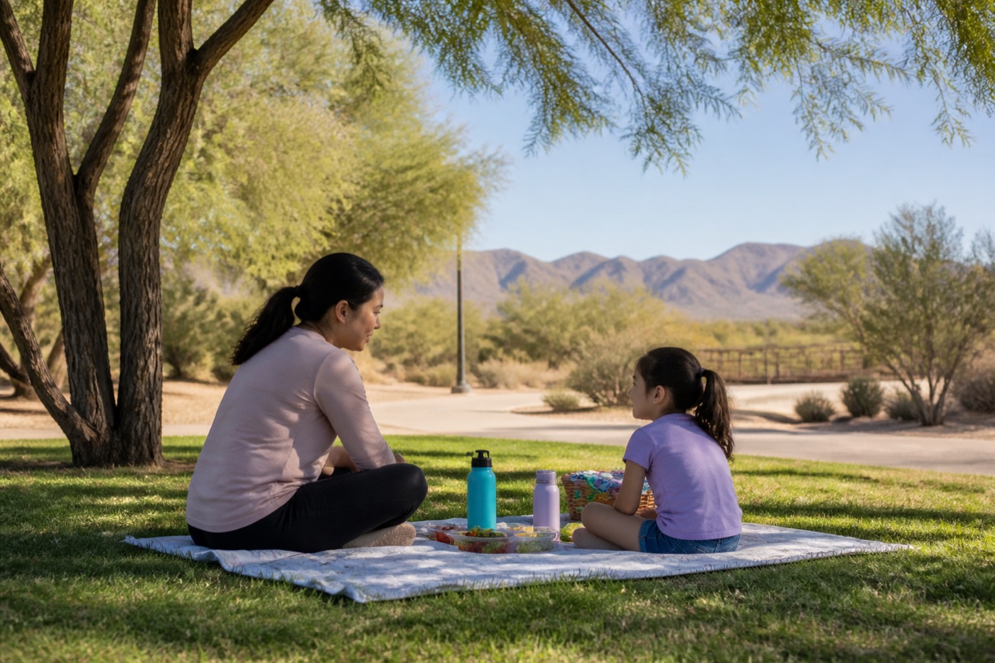 Family picnic blanket under shade trees at a quiet Las Vegas park